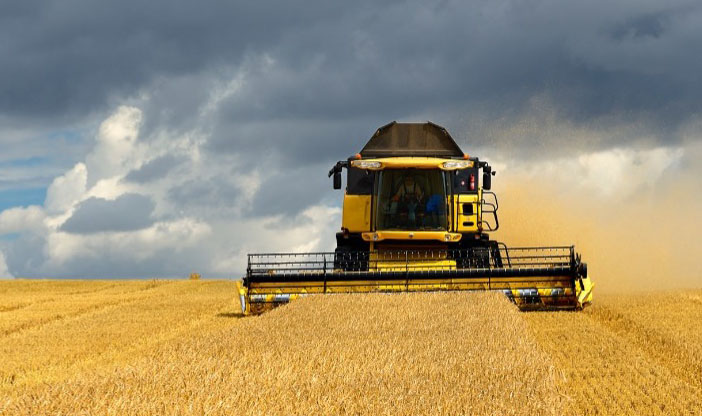 Tractor in a field with dark clouds